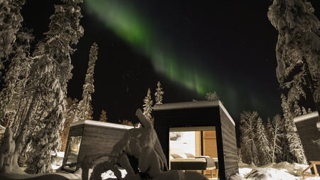 Nordlicht über den Glasvillen in der Arctic Circle Lodge