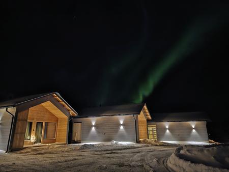 Polarlichter über den Deluxe-Villen im Holiday Village Nuorgam