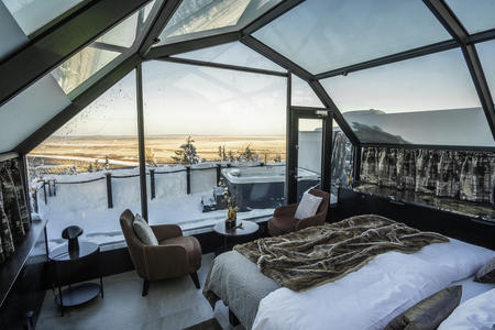 Schlafbereich mit Blick auf die Terrasse und Jacuzzi in den Suite Iglus