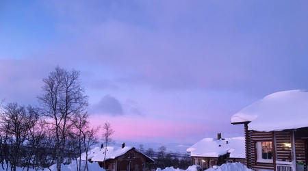 Ferienhäuser vor rosa gefärbtem Himmel (c) Kilpisjärven Tunturimajat