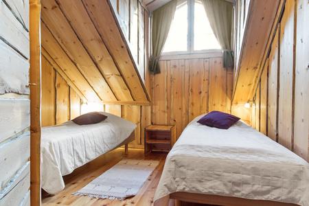 Schlafzimmer mit Schrägen Holzdecke im großen Blockbohlen-Ferienhaus 