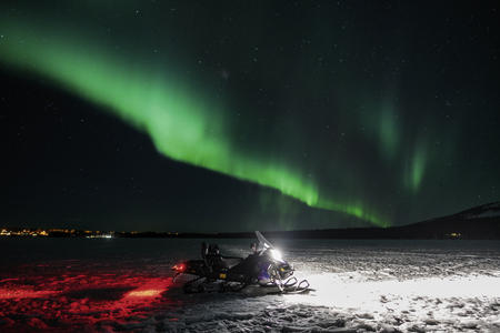Das Nordlicht zeigt sich während der abendlichen E-Motorschlittensafari