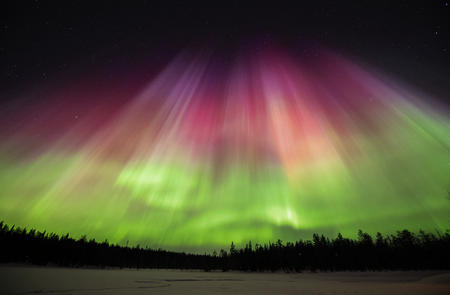 In lila und grün tanzt das Polarlicht über den Himmel